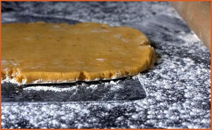 In a food processor, pulse together the shredded sharp cheddar cheese, all-purpose flour, cubed butter, salt, and paprika until the mixture resembles coarse crumbs. If you enjoy a little extra kick, you can add garlic powder at this stage for additional flavor. Gradually add cold water, one tablespoon at a time, while continuing to pulse until the dough begins to form. The dough should come together smoothly, forming a cohesive ball that is easy to handle.